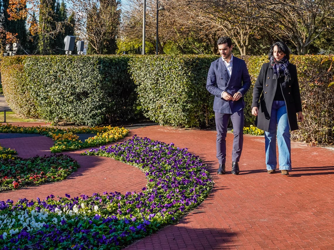 Pareja caminando por jardines con flores en Torrejón