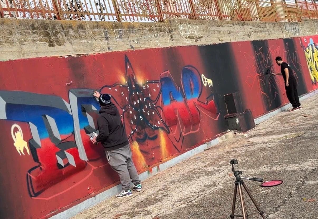 Jóvenes pintando un mural inspirado en Stranger Things en Mejorada del Campo