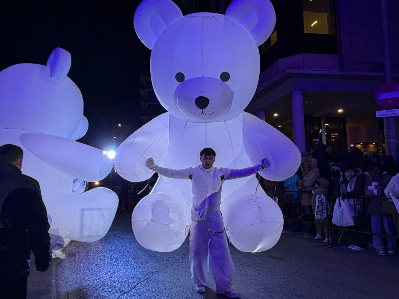 Persona sosteniendo un gran oso de globos en la cabalgata de Reyes
