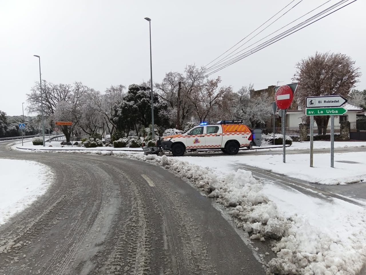 Vehículo de emergencia en una carretera nevada en Villalbilla